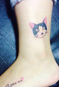 Little cat head tattoo lying on the white calf