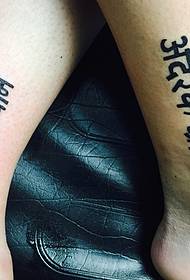 Very rudimentary low-key calf couple Sanskrit tattoo