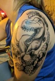 검은 쏘는 간단한 선 꽃과 공룡 문신 사진에 여자의 큰 팔