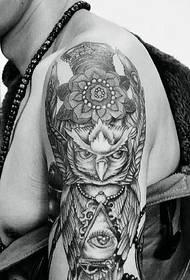 Big arm tattoo combined with owl head and geometric eyeball