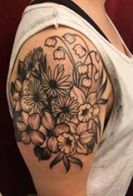 O brazo grande da rapaza no punto negro espinosa liña de planta planta fermosa tatuaxe de flores
