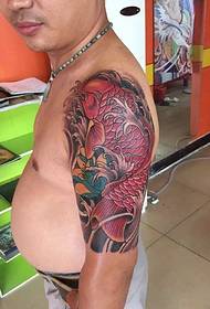 Padharan bir nyorot tato snapper abang ing lengen wong