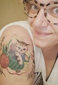 Большая рука девушки с татуировкой Китти на цветных маленьких свежих татуировках кота