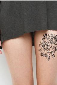 Fashionable black and white rose pattern on girl thigh