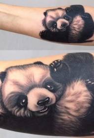 Juodai balta, miela, maža panda, žaidžianti su tatuiruotėmis ant rankos galo
