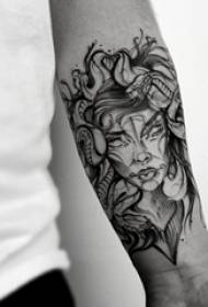 Gyvatės ir mergaitės tatuiruotės modelio berniuko neapdorota ranka ant gyvatės ir mergaitės tatuiruotės paveikslėlio