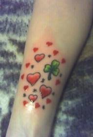 Color del braç de molts cors vermells i patró de tatuatge de trèvol