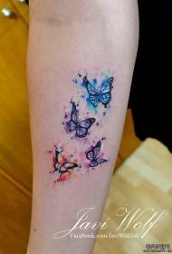 Malena ruka prskana bojom tinte u obliku u obliku leptir tetovaža