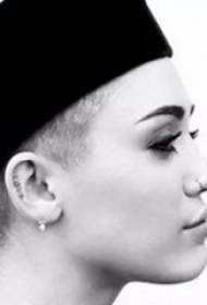 ynternasjonale tattoo-stjer Miley Cyrus earen op swarte Ingelske tatoeaazjefoto's