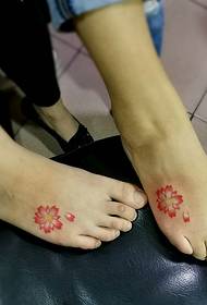 uma linda tatuagem de flor de cerejeira no peito do pé