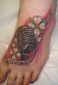 Kāpnes krāsoti dižskābarža ziedi un mikrofona tetovējuma raksts