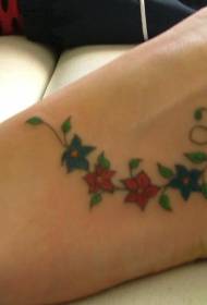 krāsains ziedu vīnogulāju tetovējuma raksts uz kājas