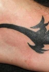 Kāju tetovējums ar melnu ķirzaku