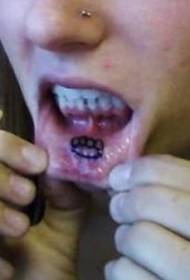 black logo tattoo on the inside of the lips