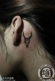 Depois da orelha da mulher, uma pequena tatuagem de antílope fresca trabalha