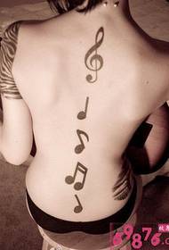 dekle s črno-belo glasbeno tetovažo na hrbtu