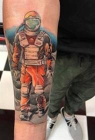 Spalvotas kosmonauto tatuiruotės paveikslas ant rankos