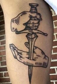 Черен ръчен меч в минималистичен стил, пробит в татуировката на модела в ръката