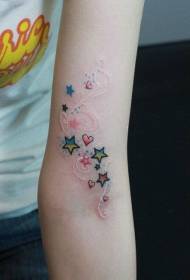 Skaistas sievietes rokas ar jauku sirds formu un piecu zvaigžņu tetovējuma zīmējumu