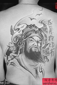 Ang likod ng batang lalaki ay sikat sa isang cool na tattoo ng kampanilya
