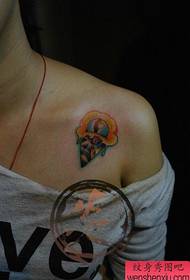 Un pequeño patrón de tatuaje de helado en los hombros de una bella mujer