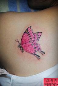 Smuk pige med en smuk sommerfugl tatovering på skulderen