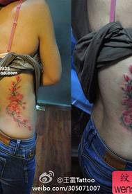 Babae baywang maganda naghahanap ng makulay na pattern ng floral tattoo