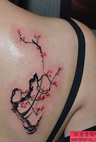 Krásne dievčenské krásne slivkové tetovanie na chrbte