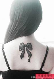 Beautiful female lace bow tattoo on the back of the girl