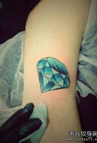 Spalvingas deimantų tatuiruotės modelis ant gražios moters rankos vidinės pusės