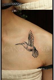Small hummingbird tattoo pattern on the shoulder of a beautiful woman