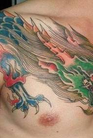 Правая рука мужчыны на сінім праз плячо цмокавым малюнкам татуіроўкі