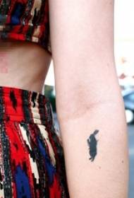 Schoolgirl arm on black small animal bunny silhouette tattoo picture