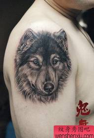 Brazo masculino clásico patrón de tatuaje de cabeza de lobo gris negro súper guapo