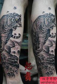 He tama he pera ki nga waewae ki raro i te tauira tattoo tiger maunga