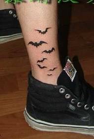 črni netopirni vzorec tetovaže na zunanji strani noge