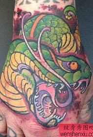 un popular patrón de tatuaje de cabeza de serpiente en el dorso de la mano
