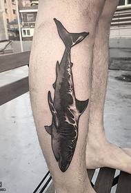 een tattoo met zwarte haaien op het kalf