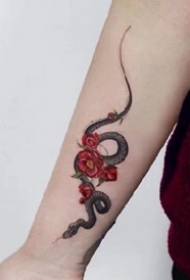 una foto di un bellissimo serpente nero con un'opera d'arte del tatuaggio fiore rosso