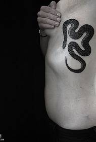 hrudník pokrytý hadím tetovaním