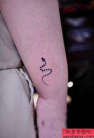 girl's arm a totem snake tattoo pattern