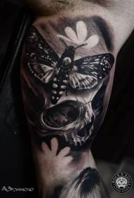Black and white skull and butterfly tattoo on the inside of the boom
