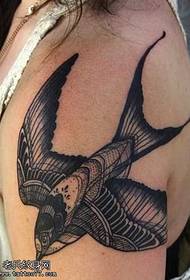 Patron de tatuatge d'oreneta en blanc i negre de braç