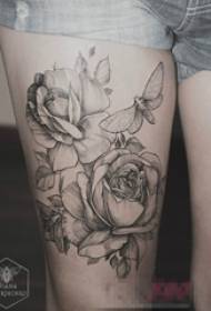 Foto de tatuaje de animalito y flor con manchas grises femeninas en el muslo