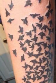 suuri joukko mustia lintuja lentäviä tatuointikuvioita