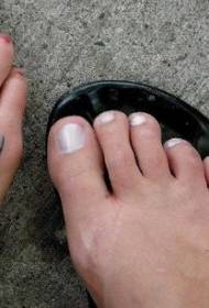 Two bear paw print tattoos on the instep