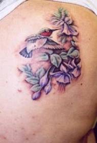 Mga violet na may kulay na binti na may pattern ng hummingbird na tattoo