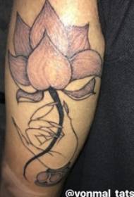 Zēna roka uz melnā pelēkā punkta ērkšķa vienkāršas līnijas augu lotosa tetovējuma attēla
