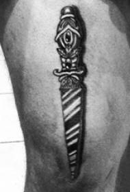 Chico muslos en punto negro espina línea simple planta y daga tatuaje foto