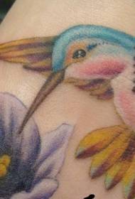 Feet colored cute little hummingbird with flower tattoo